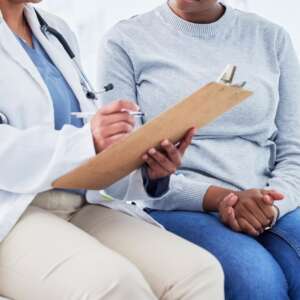 Doctor, women and checklist in healthcare support, hospital services and patient history, charts or results. Senior nurse writing on clipboard for registration, clinic sign up or medical consultation